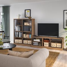 a living room filled with furniture and a flat screen tv on top of a wooden entertainment center