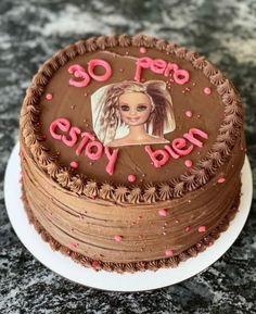 a chocolate cake decorated with an image of a woman's face on top and pink sprinkles