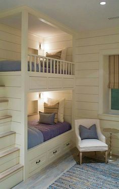 a white bunk bed sitting next to a chair