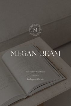 an open book sitting on top of a wooden table next to a white couch with the title megan beam