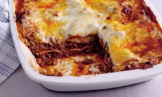 a casserole dish with meat and cheese in it on a white table cloth