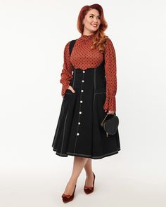 This delightful suspender swing skirt is crafted in a stylish black denim bengaline! It fastens with a button down and features front pockets. Get yours now in sizes XS-5X before they're gone! This plus size skirt pairs easily with a fun printed blouse or a basic tee Unique Vintage Unique Vintage Black Denim Button Suspender Swing Skirt | Black | Skirts | Materials & Care Instructions: ['6% Spandex, 59% Cotton, 35% Nylon', 'Hand wash', 'Imported'] Vintage Plus Size Fashion, Plus Size Vintage Fashion, Button Suspenders, Uv Clothing, Teacher Dresses, Plus Size Skirt, Nashville Outfits, Plus Size Vintage, Black High Waist