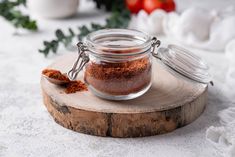 a jar filled with spices sitting on top of a wooden cutting board