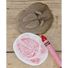 two rocks and a crayon pencil on a wooden table next to each other