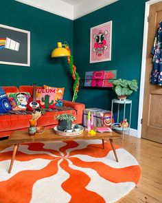 a living room with green walls and orange furniture in the center, colorful artwork on the wall