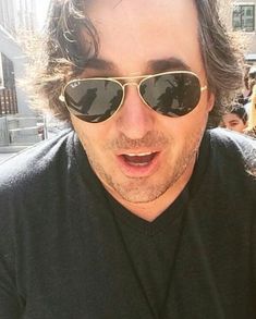 a man wearing sunglasses making a surprised face