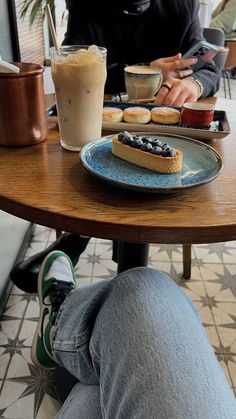 two people sitting at a table with food and drinks