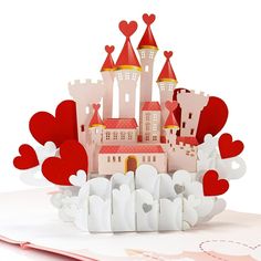 a paper cut out of a castle surrounded by hearts