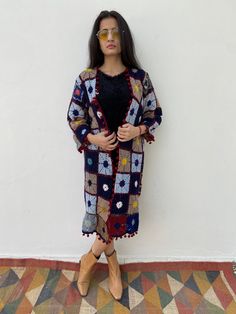 Beautiful unique geometric floral patterned wool crochet hand embroidered textile piece up-cycled into a open coat/robe. Vintage long wool cotton cardigan / coat Perfect for layering as a lunch outfit or a festival coat Effortlessly easy fit In a perfect condition Garment Measurements Chest 40 inch Shoulder 15 inch Sleeve 18 inch Length 37 inch Should fit S or M easily Please Note: Due to use of Vintage fabric almost 20-50 years old that has been up cycled, there might be some imperfections or l Bohemian Knitted Cotton Outerwear, Vintage Granny Square Outerwear For Spring, Handmade Folk Outerwear For Winter, Long Winter Outerwear With Granny Square Details, Folk Style Handmade Winter Outerwear, Handmade Folk Style Winter Outerwear, Winter Long Outerwear With Granny Squares, Hippie Long Multicolor Outerwear, Long Multicolor Hippie Outerwear