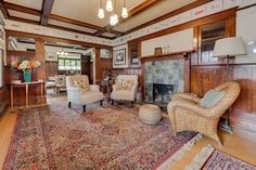 a large living room with wood paneling and ornate rugs on the hardwood floor