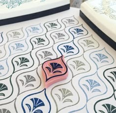 a small pink object sitting on top of a patterned floor