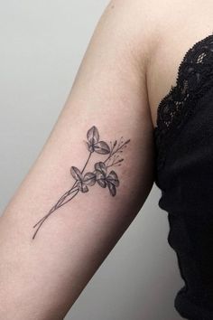 a woman's arm with a small flower tattoo on the left side of her arm