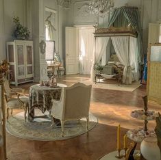 an ornately decorated living room with chandelier and table in the center area