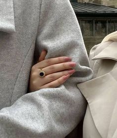 a woman with her hands on the back of another person's shoulder, wearing a ring