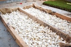 some white rocks in a wooden box on the ground