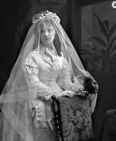 an old black and white photo of a woman wearing a wedding dress with a veil