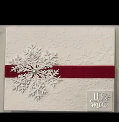 a card with snowflakes on it and a red ribbon