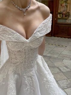 a woman in a white wedding dress standing outside