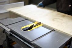 a pair of scissors sitting on top of a piece of wood next to a cutting board