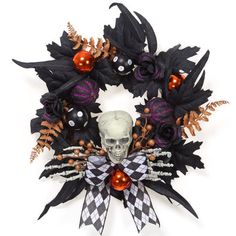 a wreath decorated with black and orange flowers, skulls and pumpkins is displayed on a white background