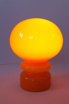 an orange lamp sitting on top of a table