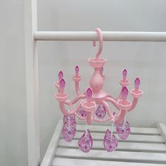 a pink chandelier hanging from a white rack