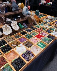 many different types of rocks and stones on display at an outdoor vendor's booth