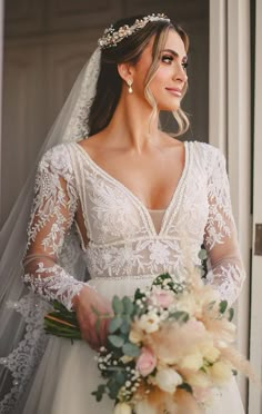 a woman in a wedding dress holding a bouquet and looking at the camera with her eyes closed