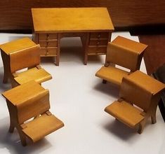 several wooden chairs and desks are arranged in a circle on a white tablecloth