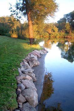 there is a rock wall along the water's edge