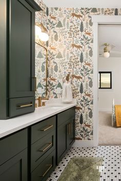 a bathroom with green cabinets and patterned wallpaper