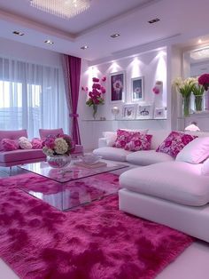 a living room filled with white furniture and pink rugs on the floor in front of windows