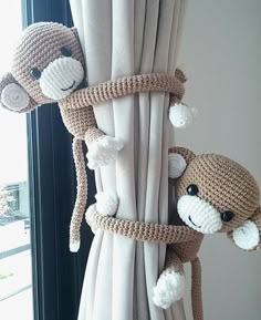 two crocheted monkeys hanging from the side of a window