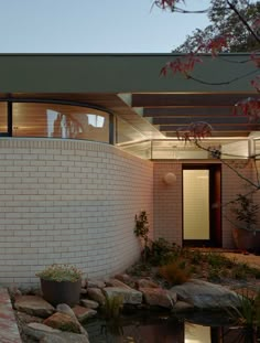 a brick house with a pond in the front yard