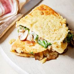 a white plate topped with an omelet and mushrooms