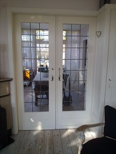 two glass doors open to a dining room with a table and chairs in the background