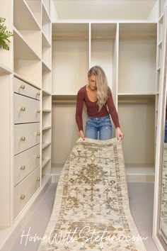 a woman standing in front of a rug on top of a wooden floor next to a white closet