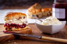 a close up of a sandwich on a cutting board near a bowl of ice cream