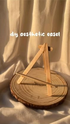 a piece of wood sitting on top of a white sheet covered ground with the words diy aesthetic easel