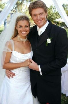 a man in a tuxedo standing next to a woman in a wedding dress