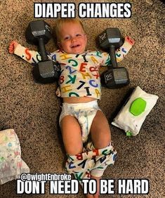 a baby is laying on the floor with dumbbells and diapers around him