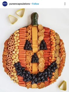 a platter made to look like a pumpkin with fruit and crackers on it