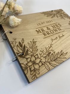 a wooden wedding guest book with flowers on the front and back cover that reads mr & mrs brown