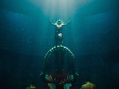 a man standing on top of a giant statue under water