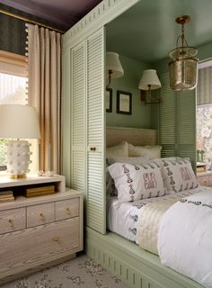 a bedroom with green walls and white bedding