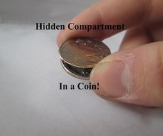 a hand holding a coin with the caption hidden compartment in a coin on it