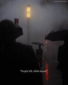 people walking in the rain with umbrellas on a city street at night, while it is raining