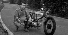 a man kneeling down next to a motorcycle