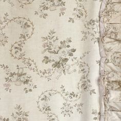 an old fashioned bed spread with ruffled edges and floral design on it's side