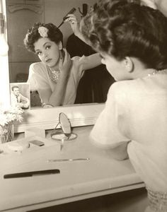 a woman is looking at herself in the mirror